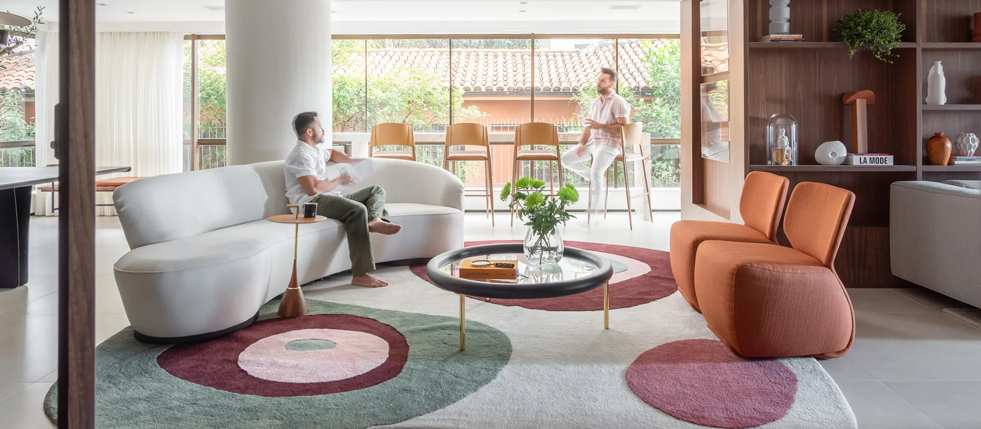 Sala com varanda integrada ganha pontos de cor e sofá curvo