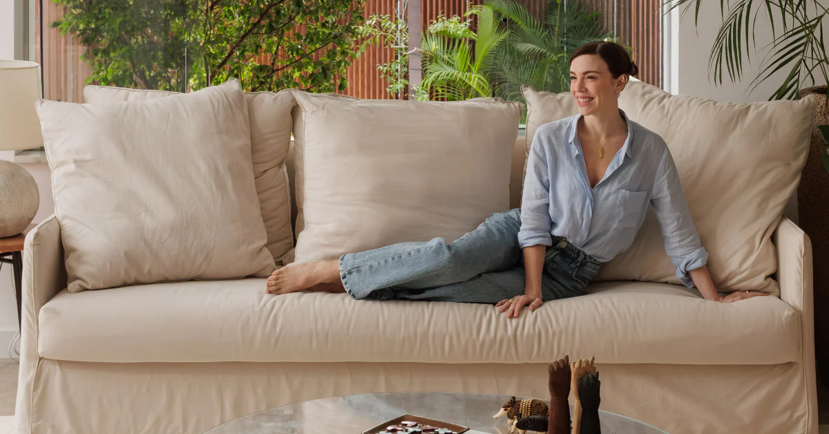 O refúgio de Alice Wegmann no Rio de Janeiro: leveza, arte e mobiliário Century 1 Atriz Alice Wegmann junto ao sofá Pitesti branco da Century em sua casa no Rio de Janeiro.